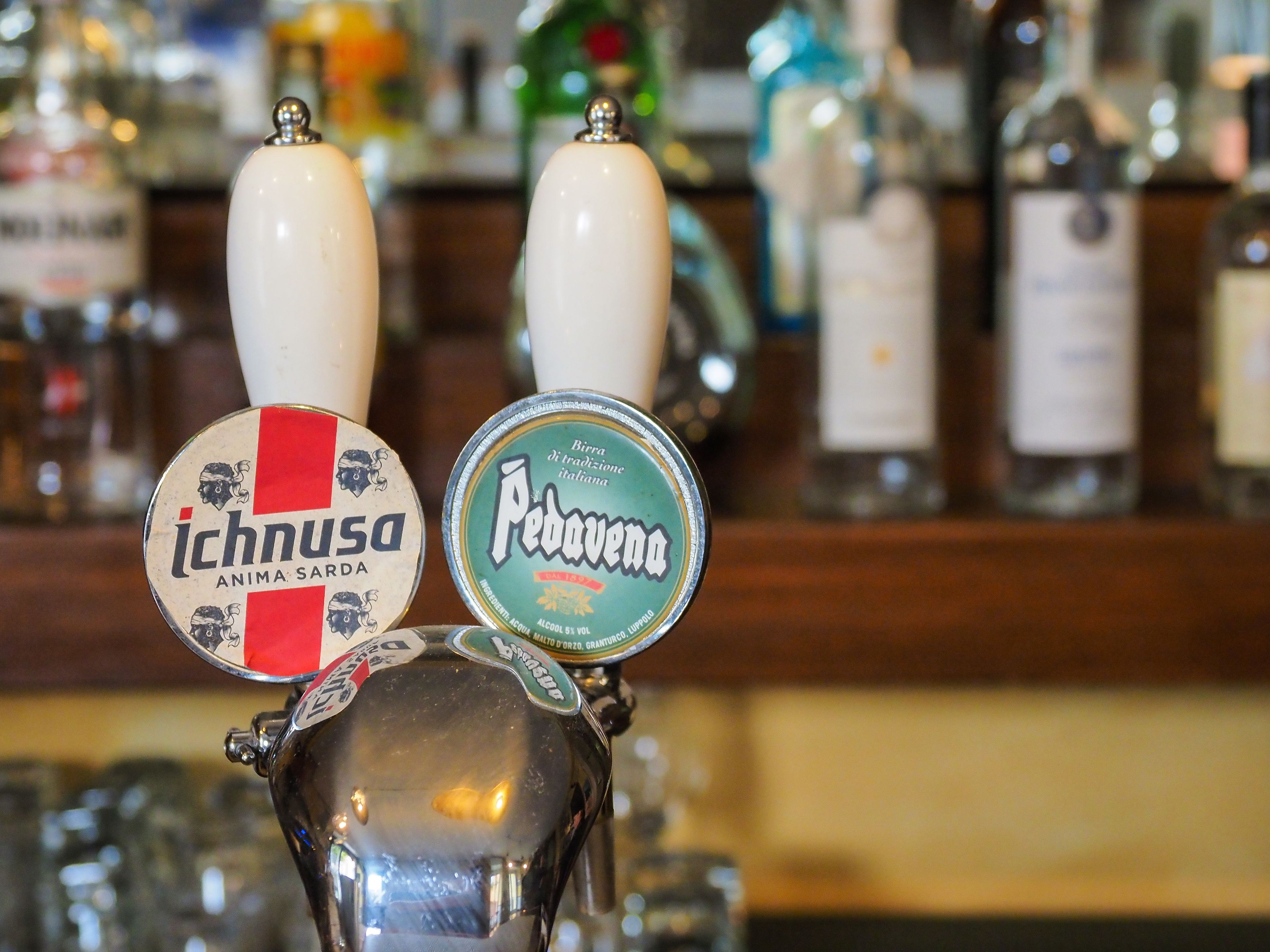 A bar with two taps labeled 'Ichnusa' and 'Piedovecca'.