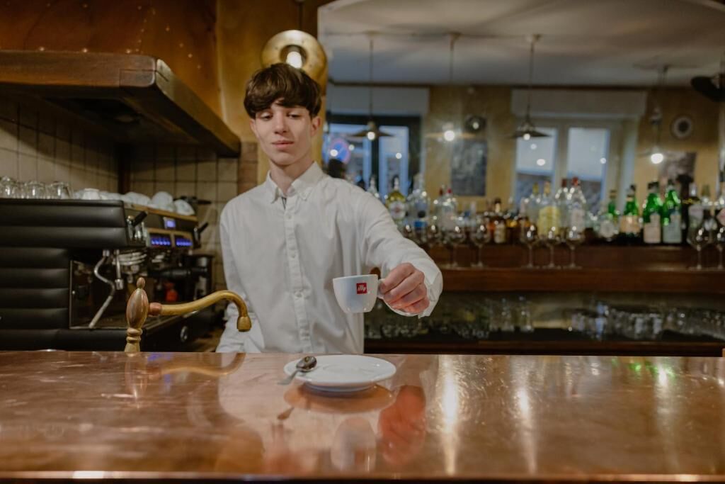 Un bar con una persona sirviendo una bebida en un vaso.