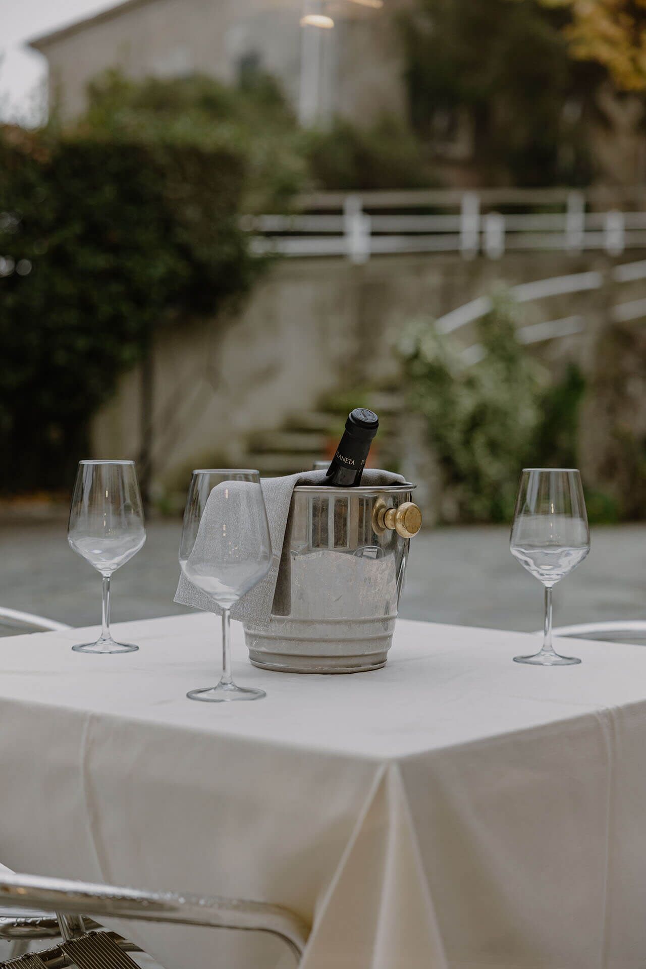 Una mesa con un cubo para champán, dos copas y una botella de champán.