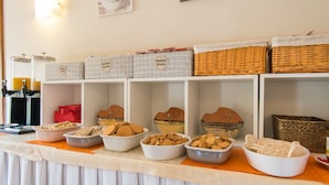 A buffet table with various food items and storage baskets. - Hotel Alpi Resort (Turin)