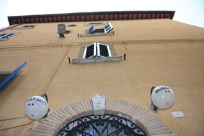 A building with a beige facade, a brick archway, and two white spherical objects with "MOLI" text. - Hotel Morlacchi (Perugia)