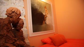 Une pièce comprenant un lit, un tableau et une sculpture aux textures variées.