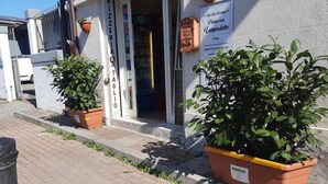 A storefront with a red awning labeled "STRAPIZZA" and a sign for "Specialità Farmaceutica Lamprediotto." - Girasole House (Florence)