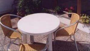 A patio with a round table and chairs, a glass door, and a spiral staircase. - Girasole House (Florence)