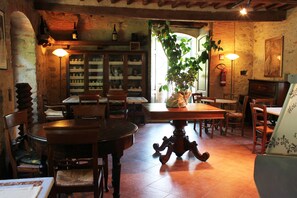Un comedor rústico con mobiliario de madera, una planta grande y una estantería para vinos.