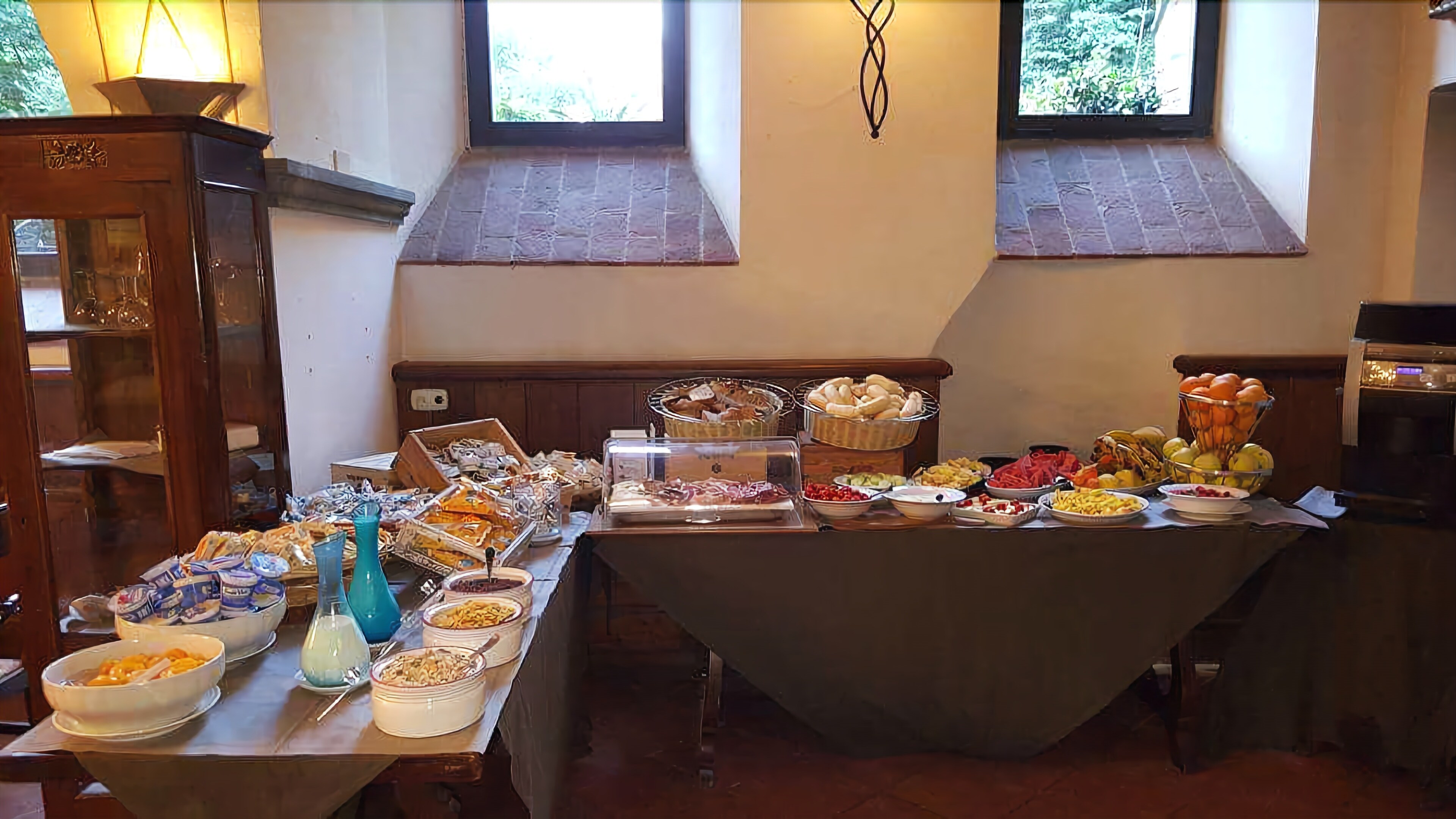 A buffet table with various food items and a wooden cabinet.