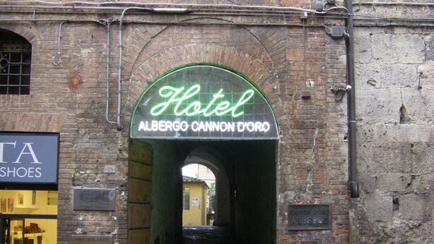 Entrada de un hotel con un letrero que dice "Hotel Albergo Cannon D'Oro Alberg".