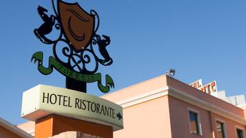 Un letrero de hotel con un escudo y una flecha indicadora.