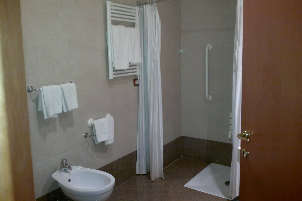 A bathroom with a shower, a sink, and a toilet.