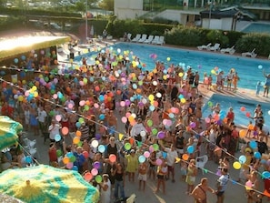 A crowded pool area with people holding colorful balloons. - Grand Eurhotel (Montesilvano)
