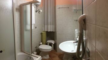 A bathroom with a shower, toilet, and sink.