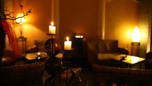 A warmly lit room with a chandelier, a table, and a sofa.