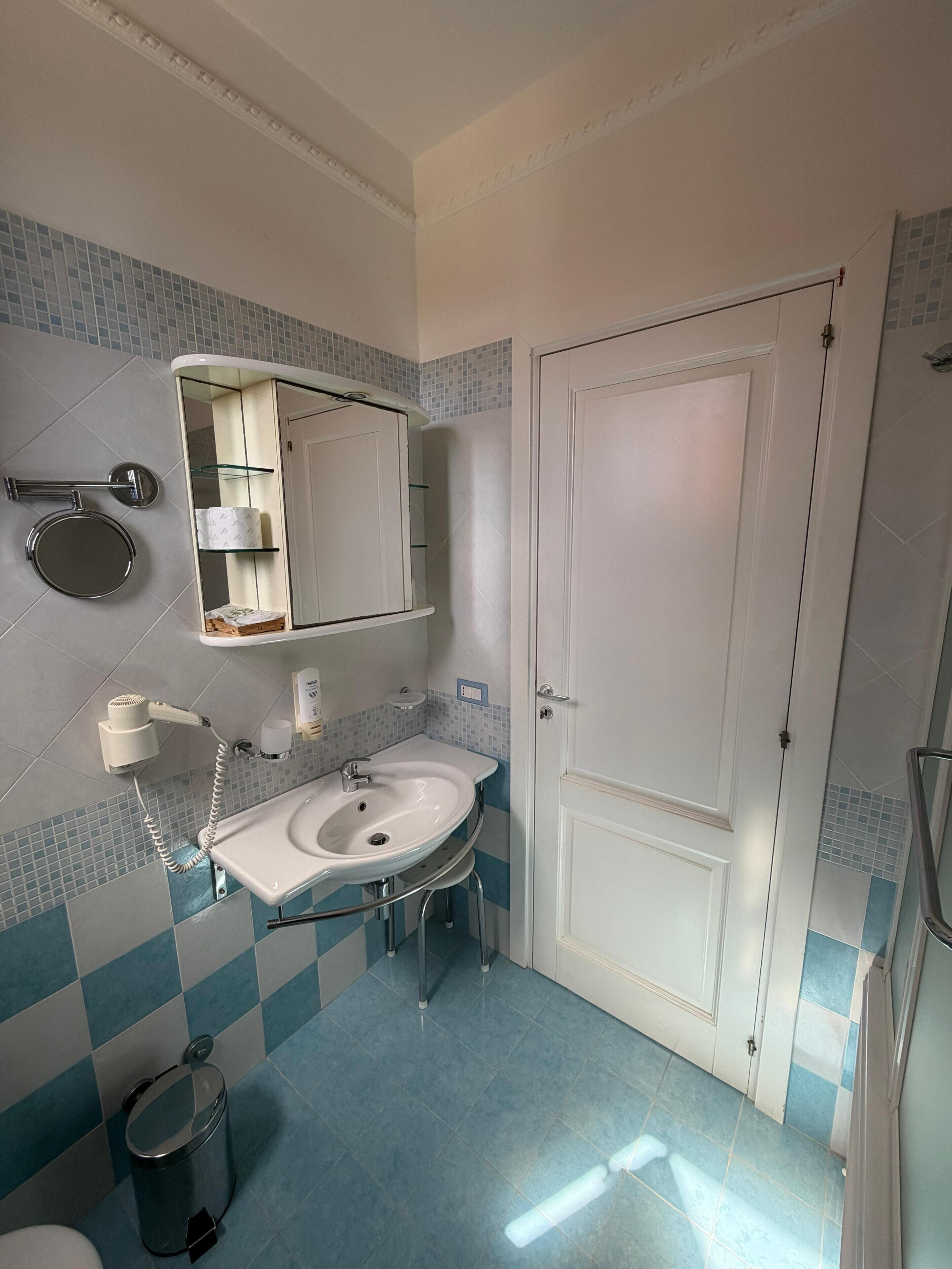 A bathroom with a sink, mirror, and toilet.