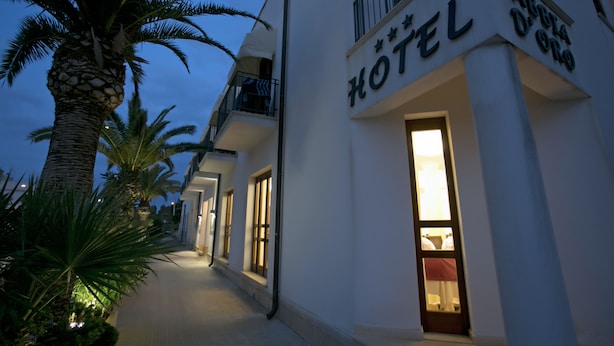 A hotel with a sign reading "HOTEL" and "SABBA D'ORO" in a white building with balconies. - Hotel Sabbia D'Oro (San Vito Lo Capo)