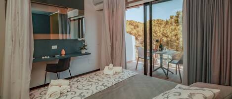 Una habitación de hotel con cama, escritorio y balcón con mesa y sillas.
