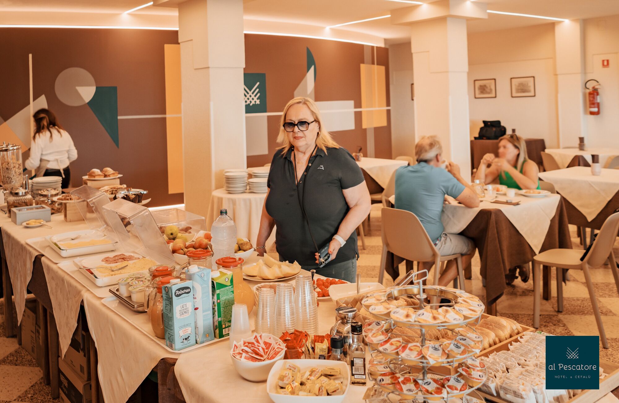 En buffet med forskellige madvarer og drikkevarer, blandt andet mælkekartoner og en vanddispenser.