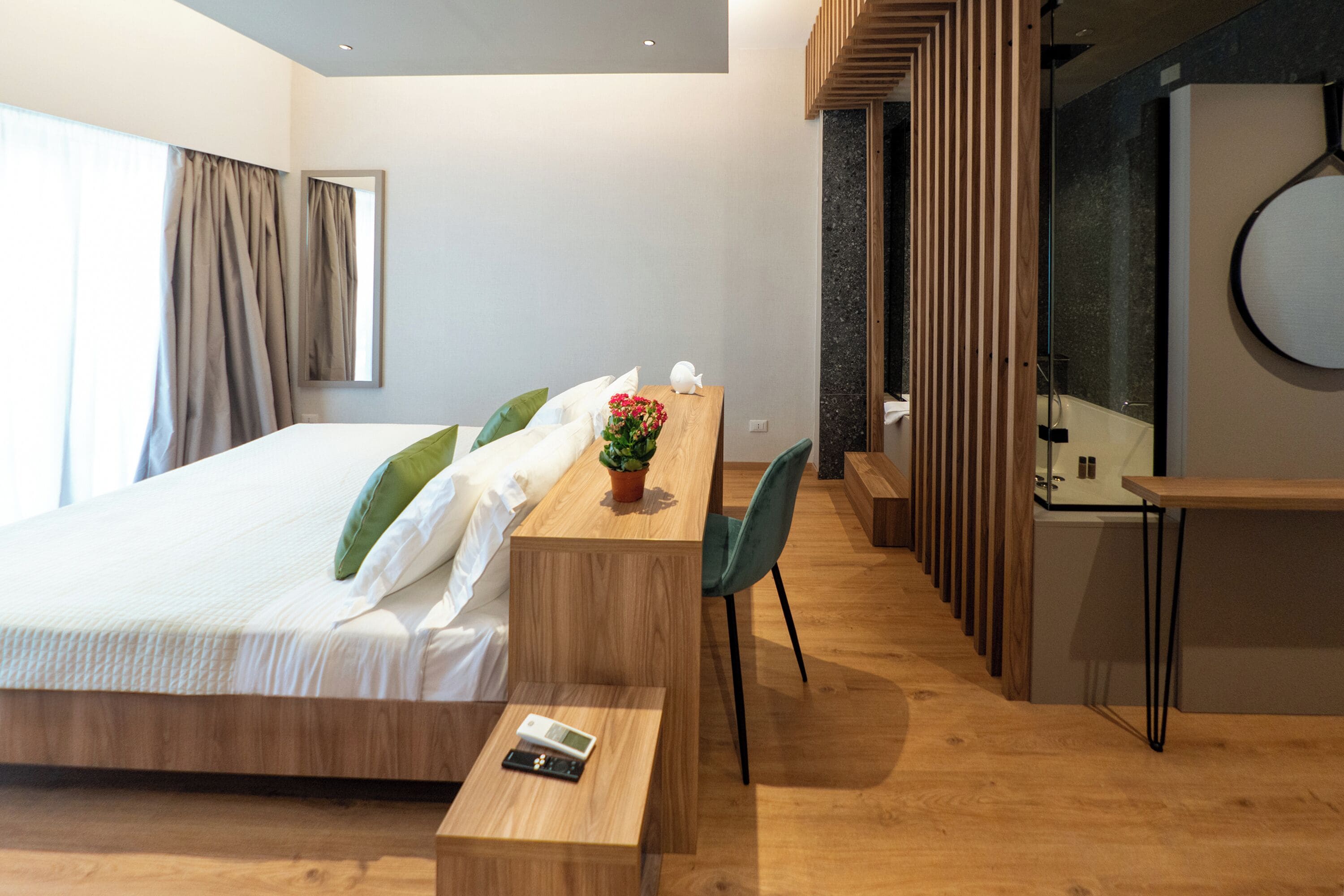 A modern hotel room with a wooden bed, a desk, and a chair.