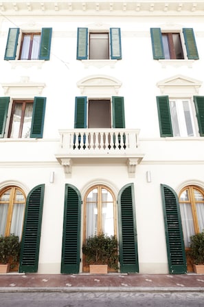 A building with multiple windows, green shutters, and a central balcony. - Hotel Savoia E Campana (Montecatini Terme)