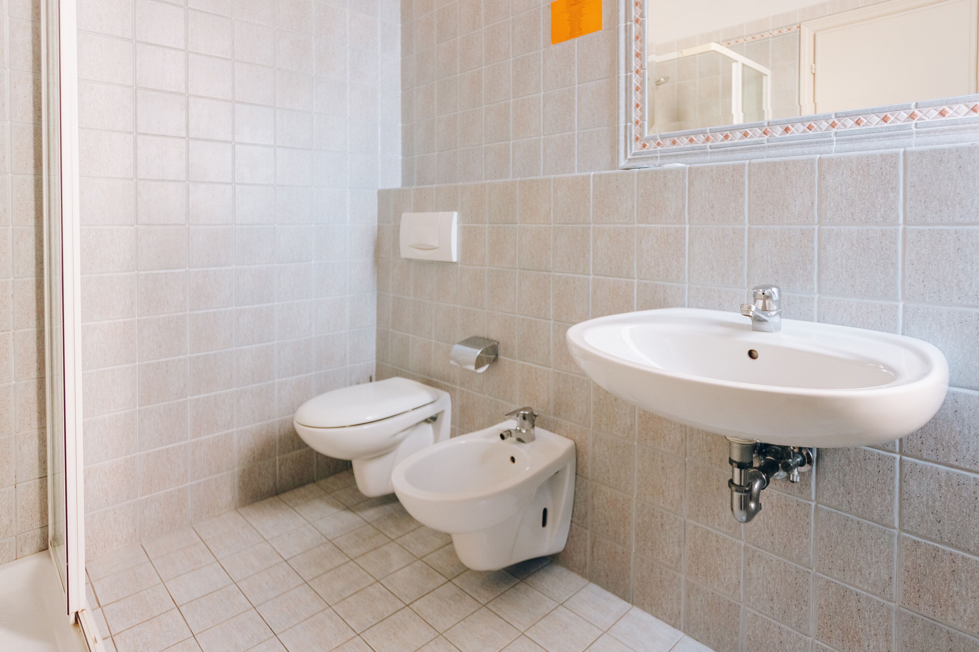 A bathroom with a toilet, bidet, and sink.