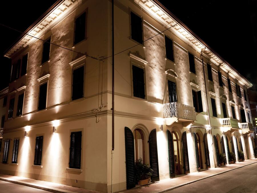 Un edificio histórico con múltiples ventanas y balcones, iluminado durante la noche.