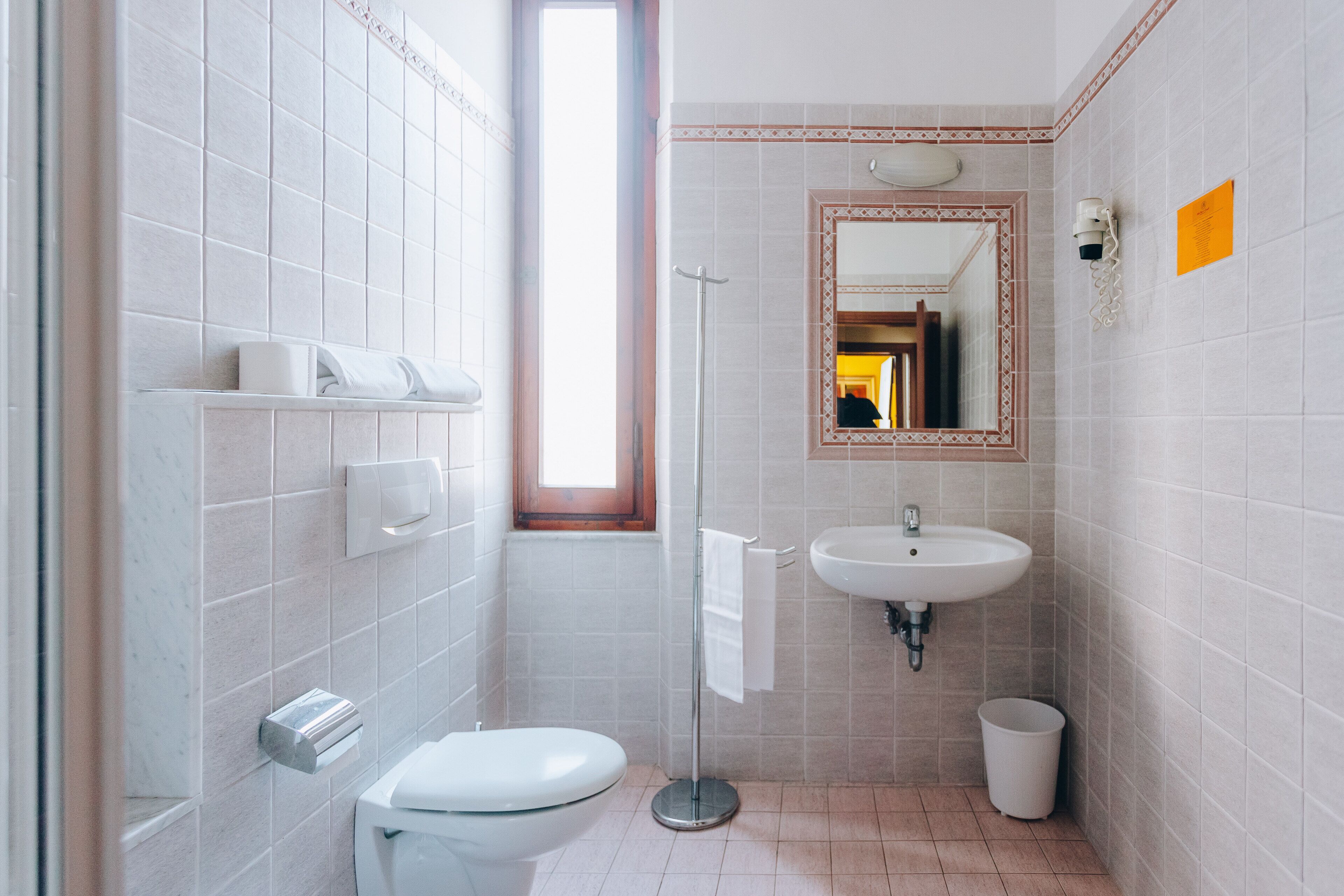 A modern bathroom with a toilet, sink, and towel rack.