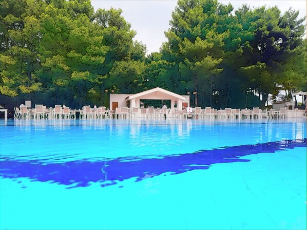 Una piscina al aire libre, tumbonas