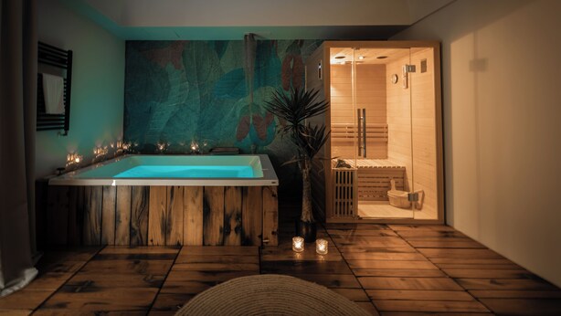 Un baño moderno con una bañera grande, suelo de madera y cabina de ducha de madera.
