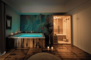 A modern bathroom with a large bathtub, wooden flooring, and a wooden shower enclosure. - Villa Favorita (Marsala)