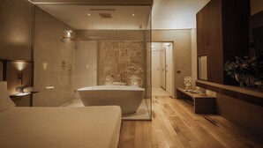 Un baño moderno con una bañera independiente, ducha y tocador con espejo.