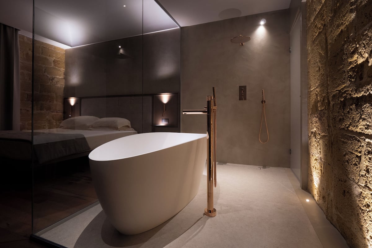 A modern bathroom with a freestanding bathtub, a walk-in shower, and a large mirror.
