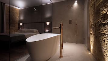 A modern bathroom with a freestanding bathtub, a walk-in shower, and a large mirror.