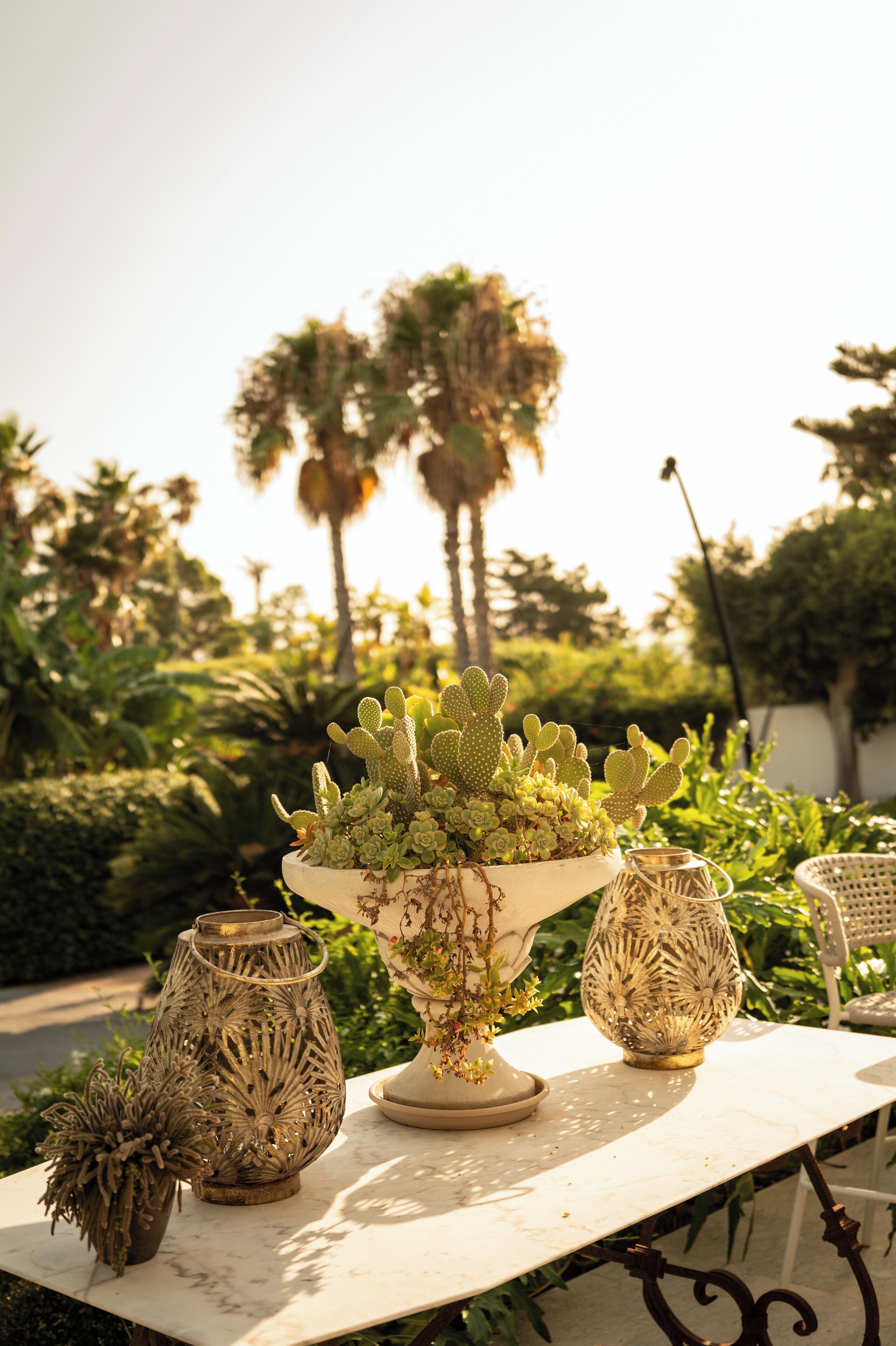 Une table ornée de trois vases décoratifs et d’un cactus.