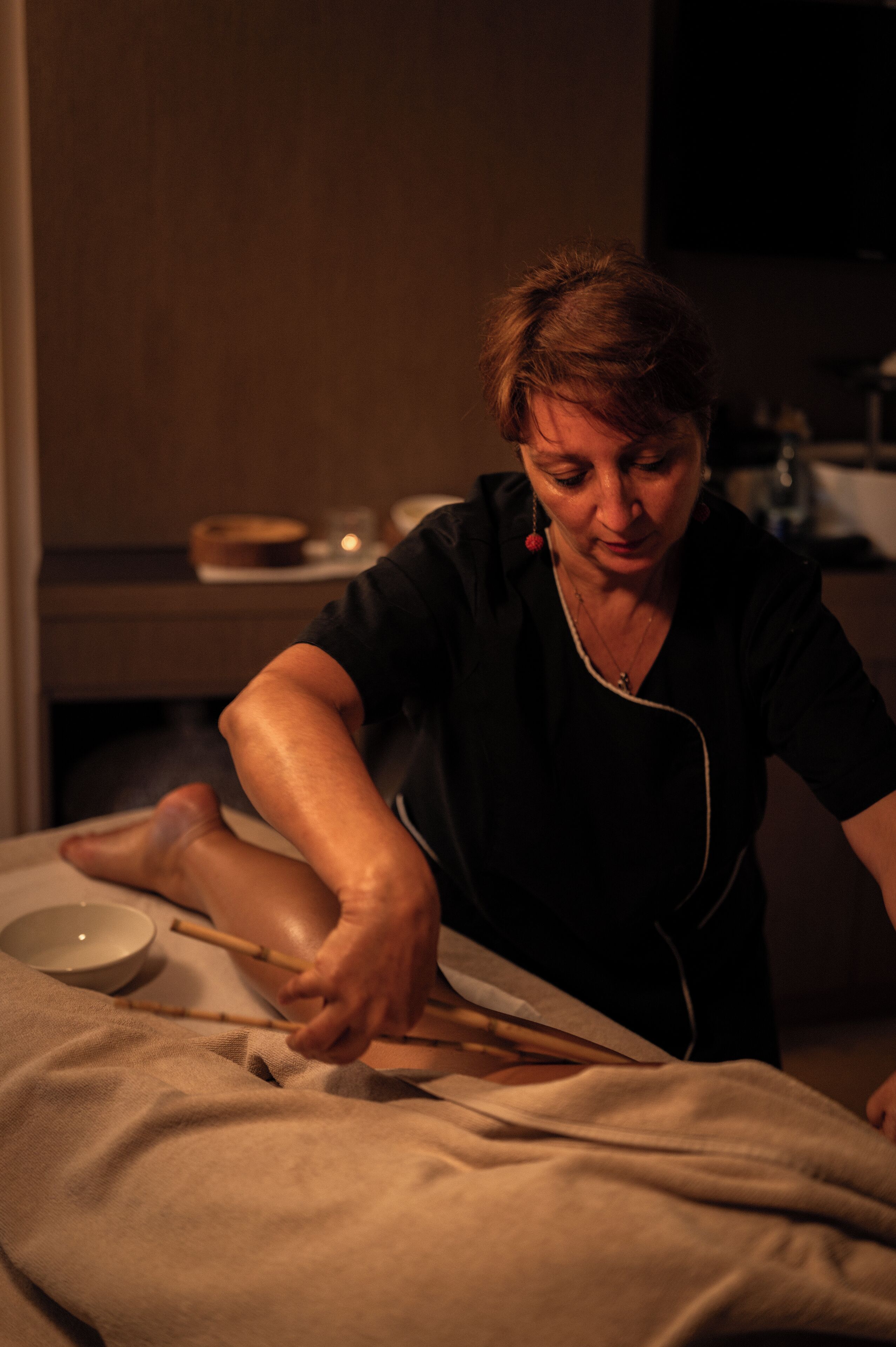 A person cooking with a bowl and chopsticks on a table.