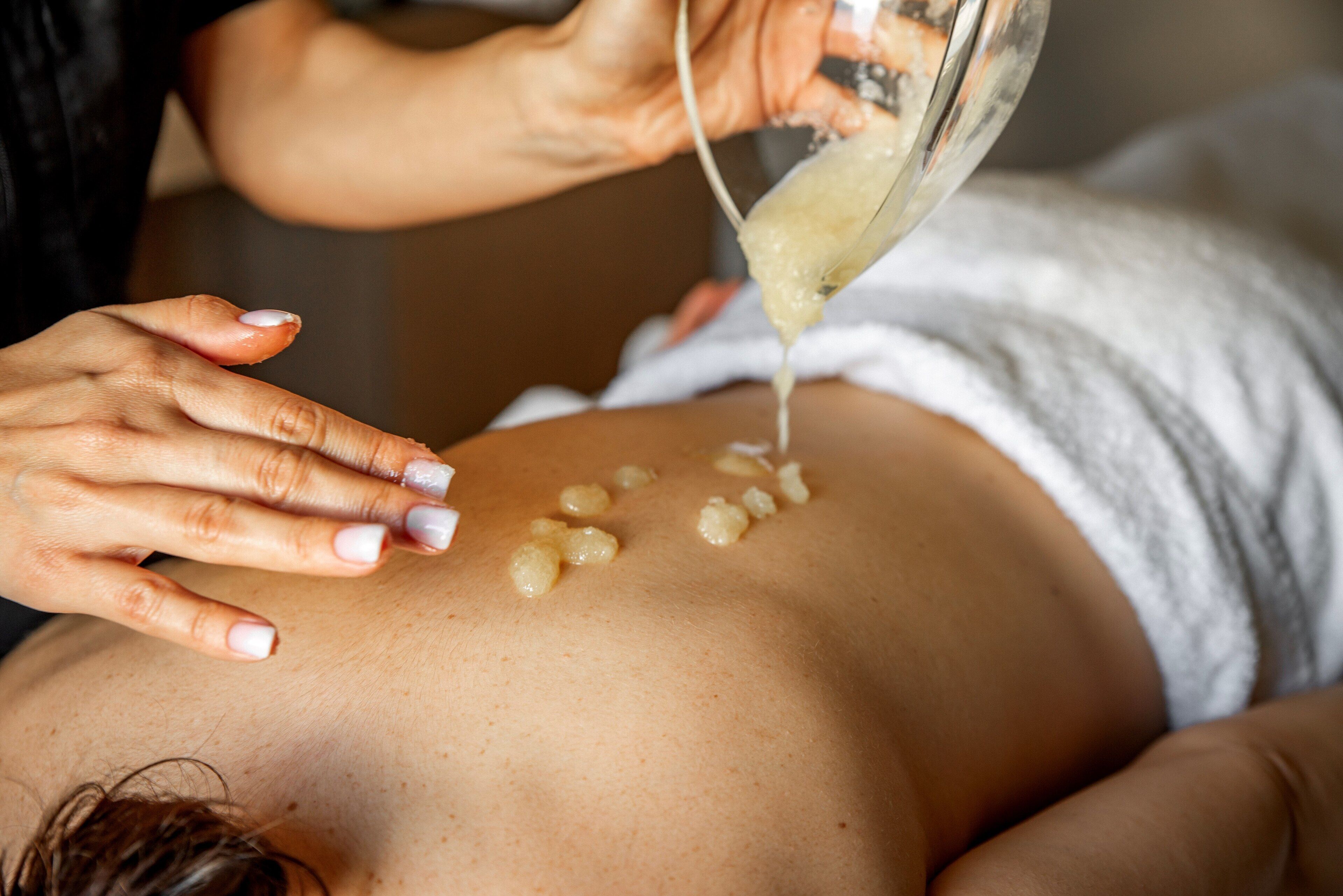 Una persona riceve un trattamento viso con un liquido applicato sulla pelle.