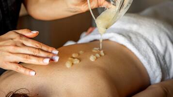 Una persona riceve un trattamento viso con un liquido applicato sulla pelle.