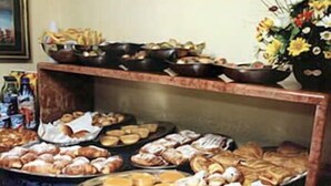 Una mesa de buffet con diversos productos de panadería y pastelería.