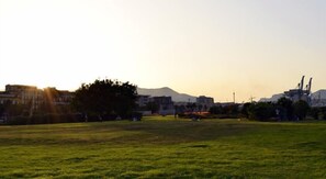 A grassy field with buildings in the background. - Hotel Villa Archirafi (Palermo)