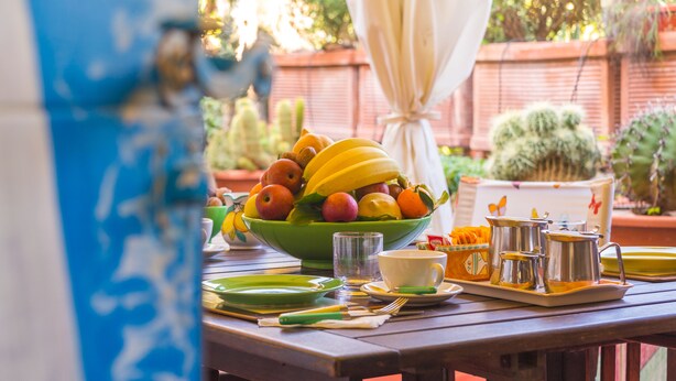 A table set with a fruit bowl, cups, and utensils. - Orchid Corner (Meta)