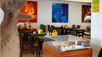 A restaurant interior with tables, chairs, and a buffet area.