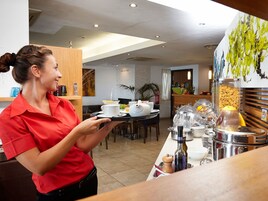 Zona de desayuno de hotel con sistema de bufé, que incluye diversos alimentos y condimentos.