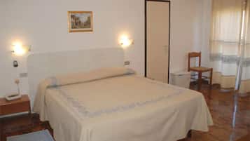 Quarto com cama, mesas de cabeceira, cadeira, guarda-roupa e um quadro na parede.