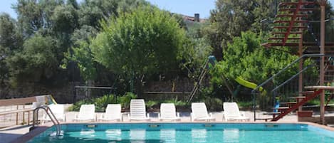 Una piscina al aire libre, tumbonas