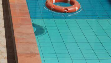 Une piscine avec une bouée de sauvetage flottant à la surface de l’eau.