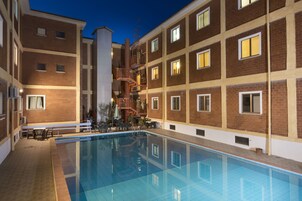 Una piscina al aire libre, sillones reclinables de piscina