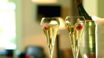 Two champagne flutes with strawberries on a bar counter.