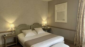 Habitación de hotel impecable con una cama grande, lámparas de noche, una mesita de noche y un espejo montado en la pared.