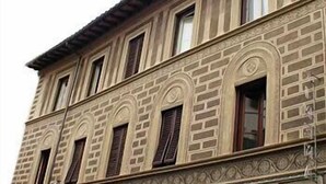 Un bâtiment à la façade symétrique, caractérisé par des fenêtres régulièrement espacées, dotées de volets et d’éléments décoratifs en briques.