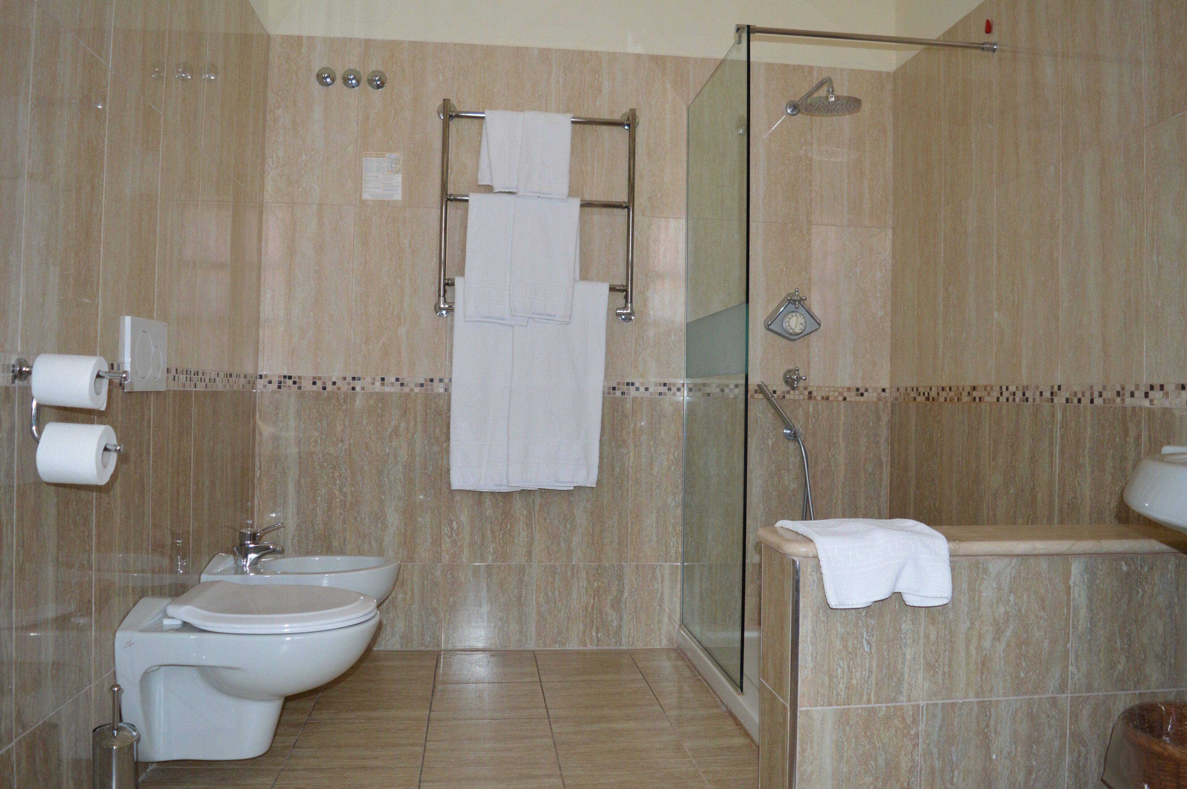 A modern bathroom with a bidet, toilet, and shower area.