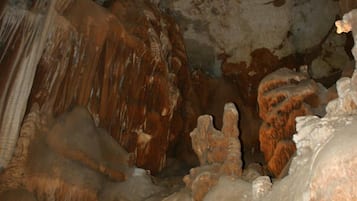 Een grot binnenin met stalactieten en -stalagmieten.