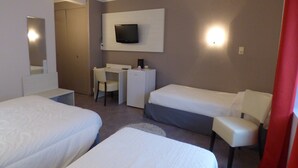 A hotel room with two beds, a desk, a chair, a television, and a mirror.